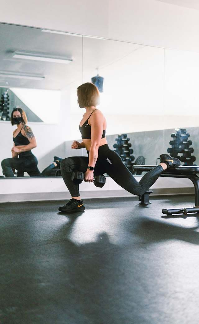 Aluna treinando sozinha com halter